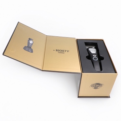 Aparelho de cortar cabelo preto na caixa dourada aberta com texto Rocket Lite Trimmer.