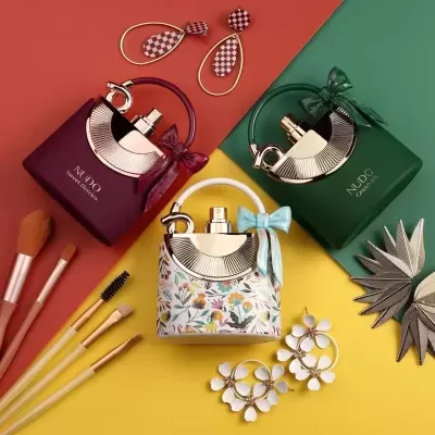 Três frascos de perfume NUDE EAU DE PARFUM com acessórios e fundo colorido