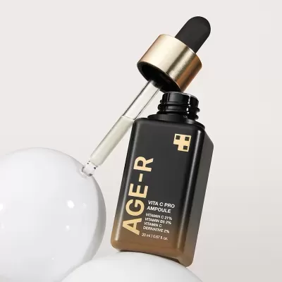 Frasco de soro facial AGE-R com conta-gotas preto e dourado