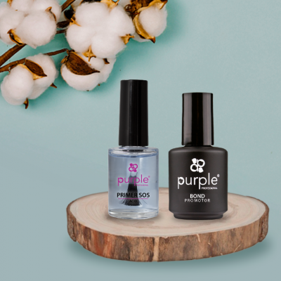 Dois frascos de verniz Purple sobre base de madeira e fundo azul com ramo de algodão.