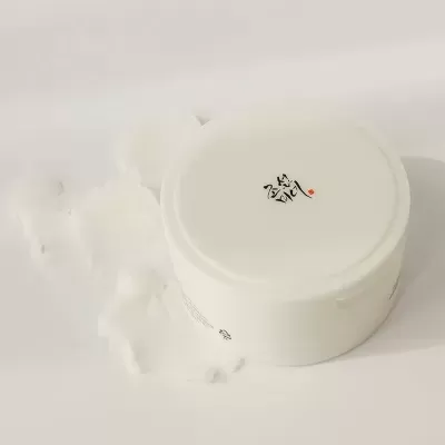 Pote branco com tampa e texto asiático no topo