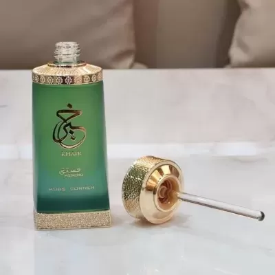 Frasco de perfume verde com tampa dourada e conta-gotas