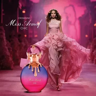 Perfume Miss Armaf Chic com modelo em vestido rosa esvoaçante na passarela
