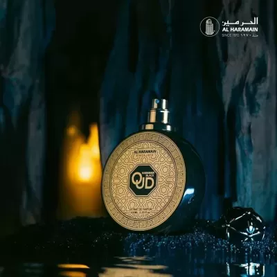 Frasco de perfume preto com rótulo dourado decorado e texto visível