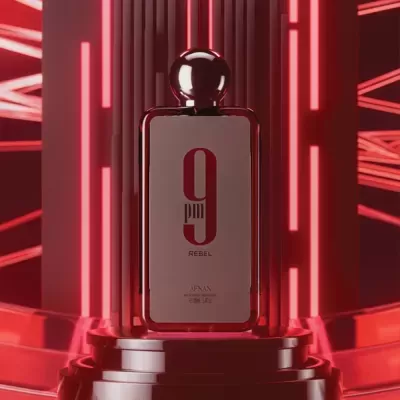 Frasco de perfume vermelho com texto 9 REBEL num pedestal e luzes vermelhas ao fundo