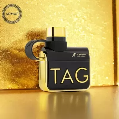 Frasco de perfume TAG preto e dourado da ARMAF em fundo dourado