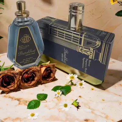 Dois frascos de perfume azul e azul escuro com rosas secas e flores brancas sobre mármore
