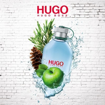 Frasco de perfume HUGO da Hugo Boss com maçã verde e folhagem sobre fundo de parede de tijolos brancos