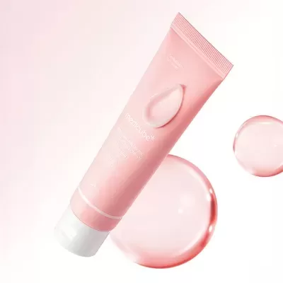 Frasco tubular rosa com creme hidratante e gotas do produto