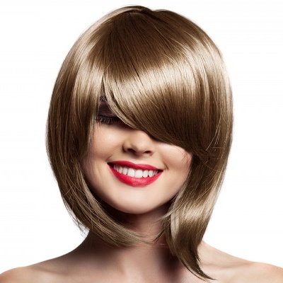 Mulher com peruca castanha clara curta e cabelo liso com franjas cobrindo os olhos em fundo branco.