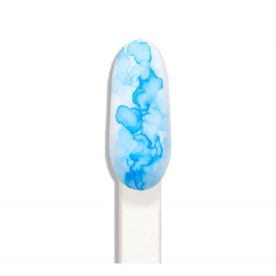 Unha artificial com padrão marmoreado azul e branco em fundo branco.