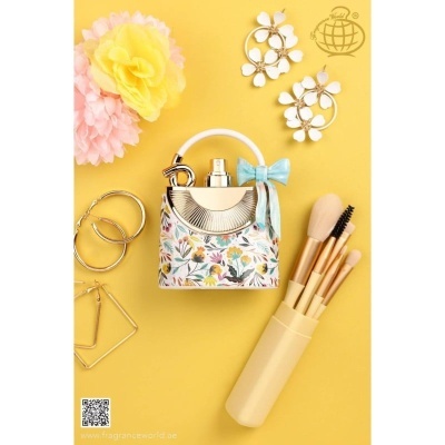 Bolsa floral colorida com frasco de perfume, pincéis de maquilhagem e brincos sobre fundo amarelo