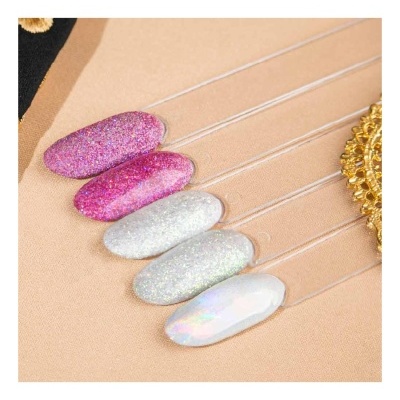 Amostras de verniz glitter rosa, prata e branco em hastes transparentes sobre fundo bege.