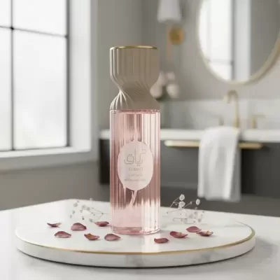 Frasco de perfume rosa com tampa bege e detalhes dourados numa casa de banho