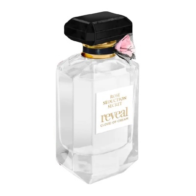 Frasco transparente de perfume com tampa preta e etiqueta branca com texto dourado