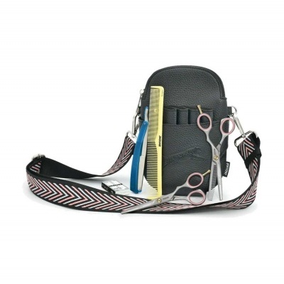 Bolsa preta com pente, navalha e tesouras, fita com padrão ziguezague vermelho, branco e preto