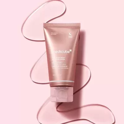 Tubo rosado de creme Medicube Collagen Night Wrapping Mask sobre fundo rosa