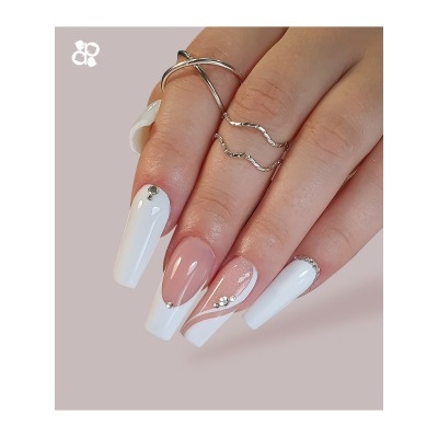 unhas longas com esmalte branco e nude com pedras decorativas e anéis de prata