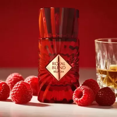 Frasco vermelho de perfume Royal Blend Séquoia com framboesas e copo de líquido âmbar