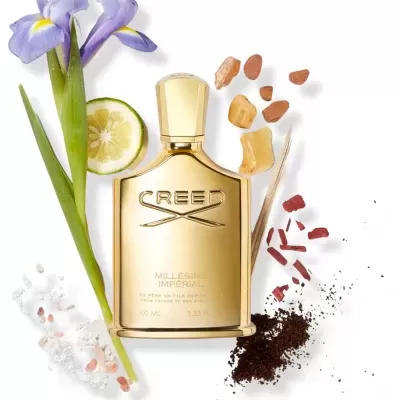 Frasco dourado de perfume Creed Millésime Imperial com elementos naturais ao redor