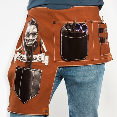 Avental castanho com bolsos em pele e design gráfico de caveira, usado com calças de ganga.