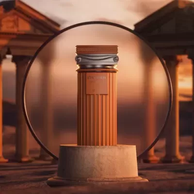 Frasco de perfume castanho com tampa prateada sobre base redonda de pedra