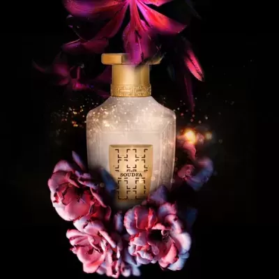 Frasco de perfume branco com flores cor-de-rosa e luzes