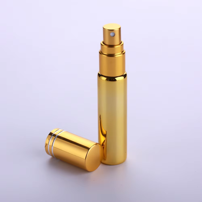 Frasco de spray dourado metálico com tampa ao lado