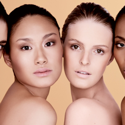 Quatro mulheres com diferentes tons de pele em fundo bege