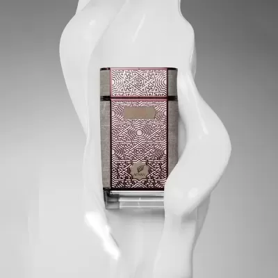 Frasco de perfume dourado com padrão geométrico e texto OUD Reserve e AFNAN envolvido por líquido branco