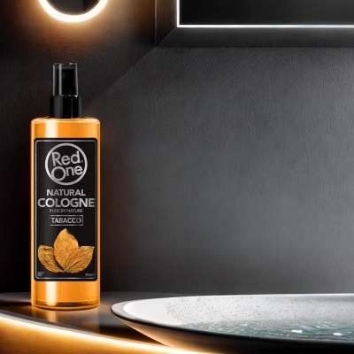 Frasco de colónia natural Red One Tabacco sobre superfície metálica dourada junto a bacia de vidro