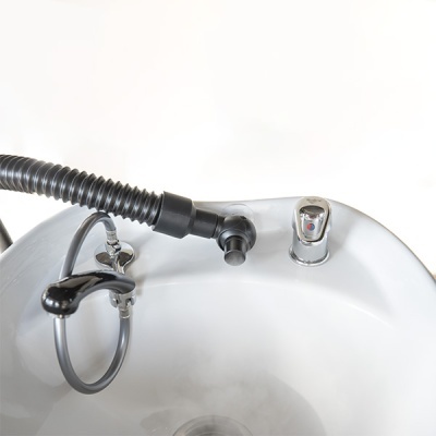 Bacia de lavagem branca com torneira e mangueira preta