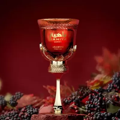 Frasco de perfume vermelho e dourado com texto BAHIYA GARNET ARABIYAT PRESTIGE em fundo vermelho com bagas escuras