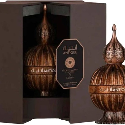 Frasco de perfume bronze com textura riscada dentro de embalagem castanha