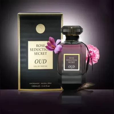 Frasco de perfume Rose Seduction Secret Oud junto à sua caixa com texto e flores rosa em fundo escuro