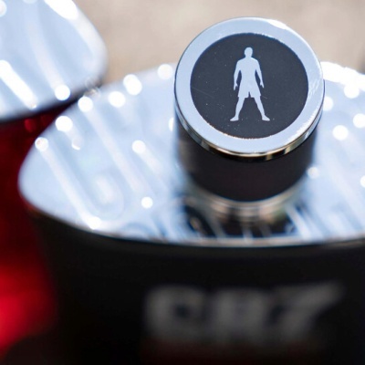 Frasco de perfume masculino com tampa prateada e emblema de figura masculina