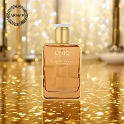 Frasco de perfume dourado Uniq Oud Forever com fundo dourado brilhante