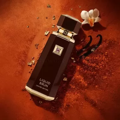 Frasco de perfume Liquit Brun sobre fundo texturizado laranja com flor e vagens