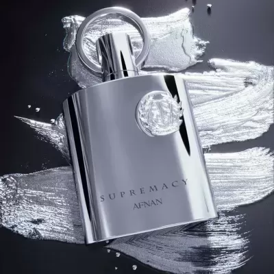 Frasco de perfume prata SUPREMACY AFNAN sobre textura prateada
