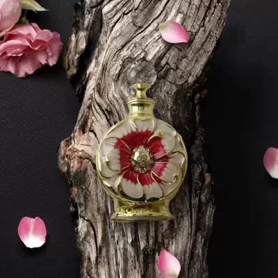 Frasco decorativo com flor vermelho e branca sobre tronco de madeira com pétalas ao redor