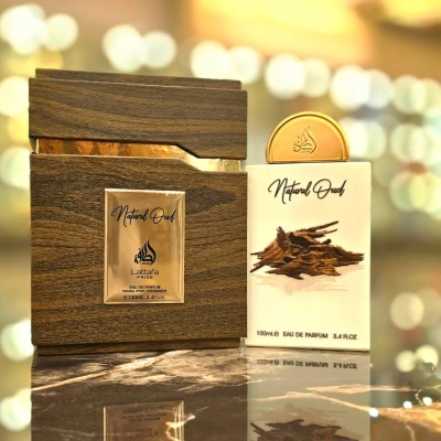 Frasco de perfume Natural Oud em madeira escura com rótulo dourado e caixa branca ao lado com imagem de madeira