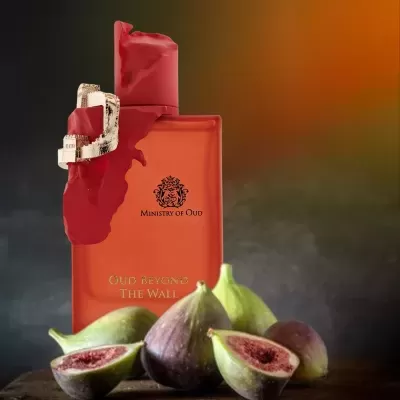 Frasco de perfume vermelho com figos frescos cortados ao meio sobre madeira