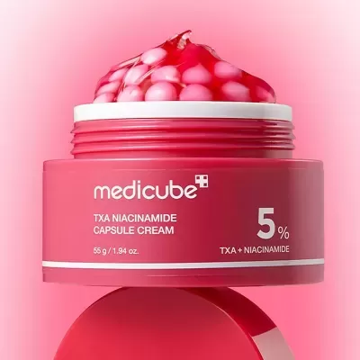 Frasco rosa de creme Medicube TXA Niacinamide com cápsulas visíveis no topo