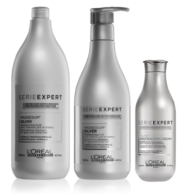 Três frascos prateados da linha Série Expert da L'Oréal, dois de champô e um de creme, com etiquetas em preto e branco.