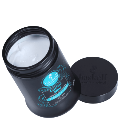 Frasco preto de creme aberto com tampo ao lado e rótulo azul e branco