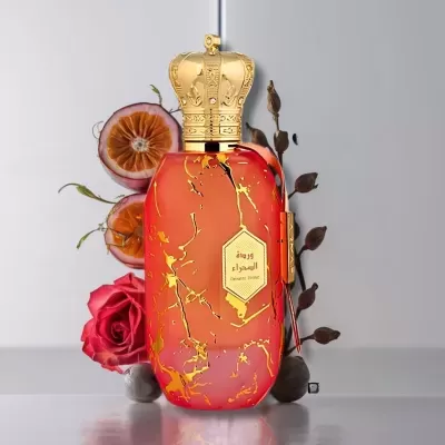 Frasco de perfume vermelho com tampa dourada em forma de coroa, rodeado por flores e frutos secos.