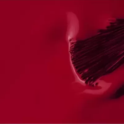 Pincel de verniz vermelho brilhante com textura cremosa