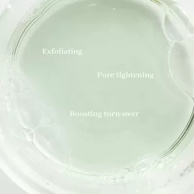 Líquido transparente com bolhas e texto em inglês no recipiente de vidro
