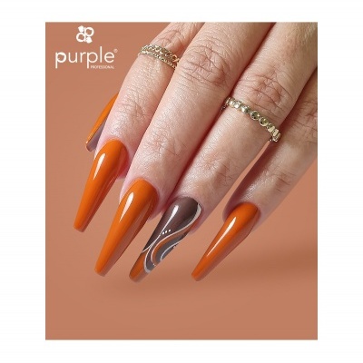 Mão feminina com unhas longas laranja e castanho decoradas, com anéis dourados e fundo laranja.