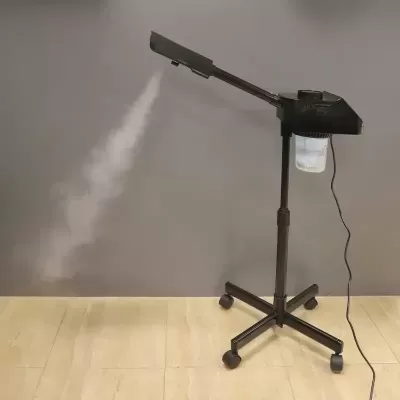 Máquina de vapor preta com rodas emitindo vapor branco